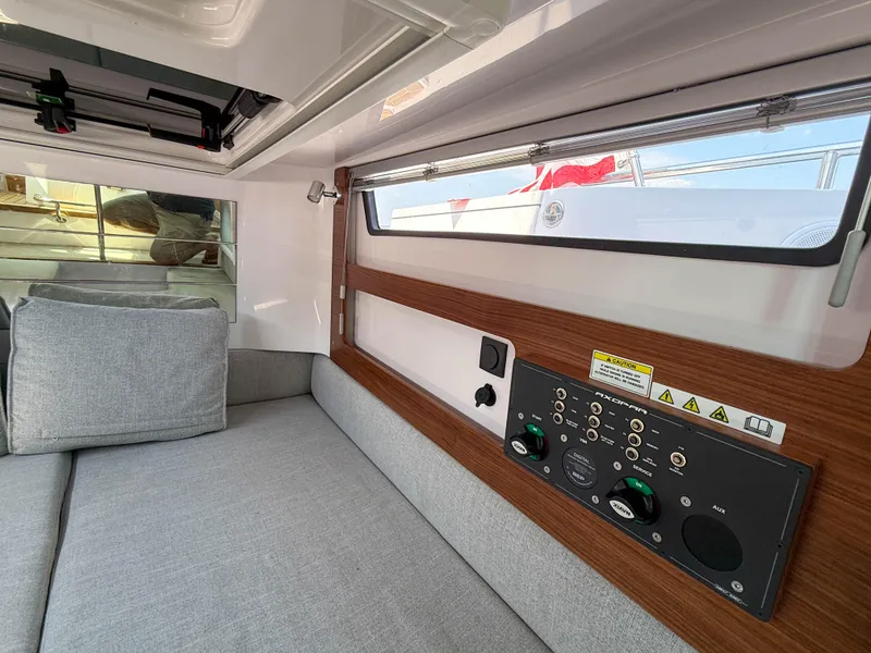 Slide: The Image of Interior of 2021 Axopar 28 CABIN with control panel and gray seating. - 14