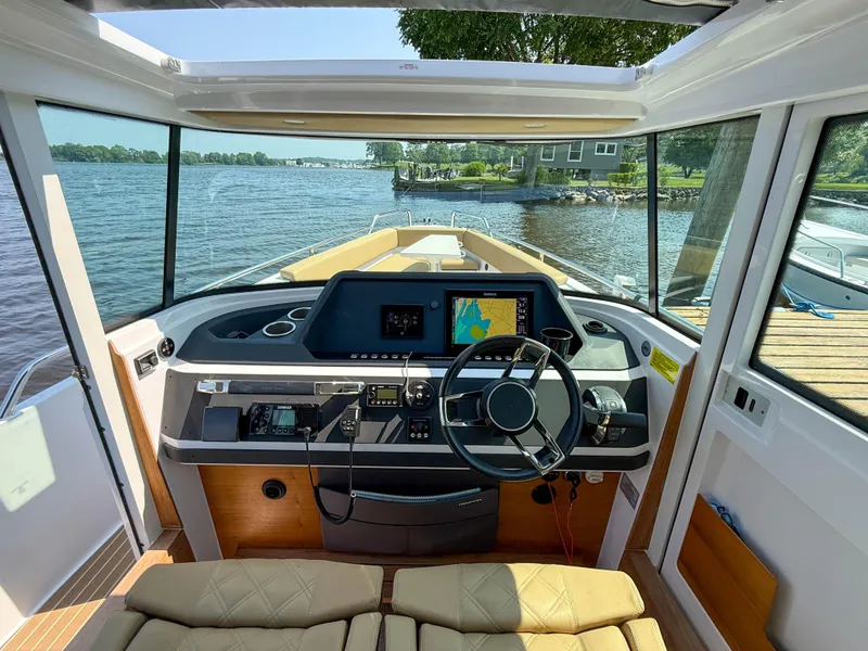 Slide: The Image of 2021 Axopar 28 CABIN boat interior with steering wheel and navigation system. - 16
