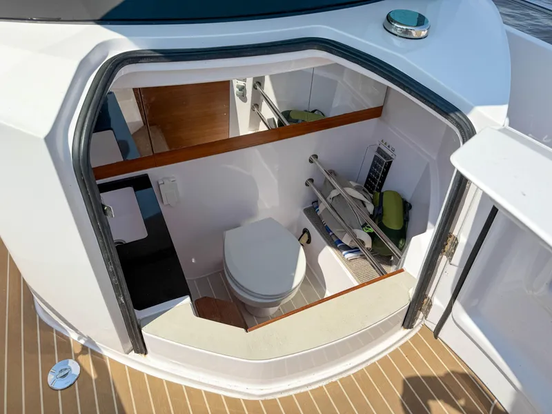 Slide: The Image of 2021 Axopar 28 CABIN boat interior with compact bathroom and storage area. - 21
