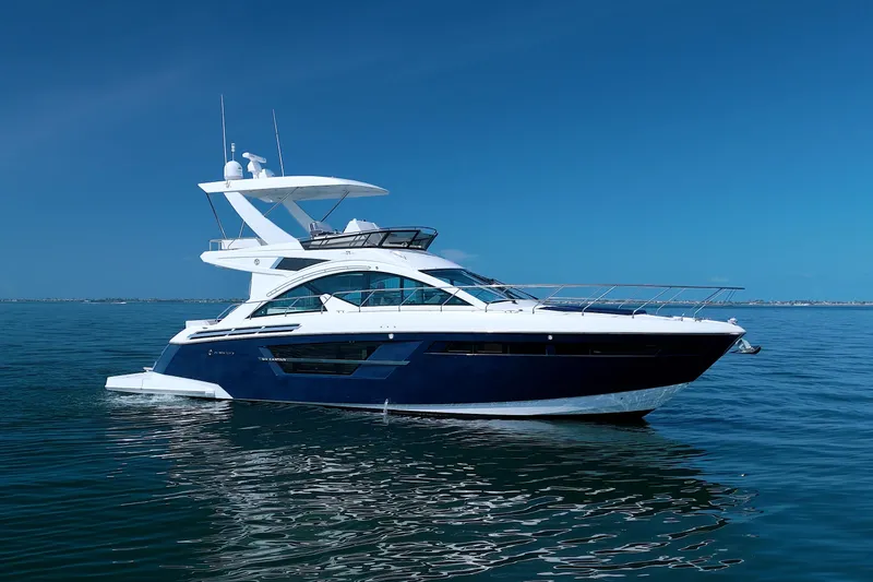 Slide: The Image of 2018 Cruisers Yachts 54 Fly on calm blue water under clear sky. - 100