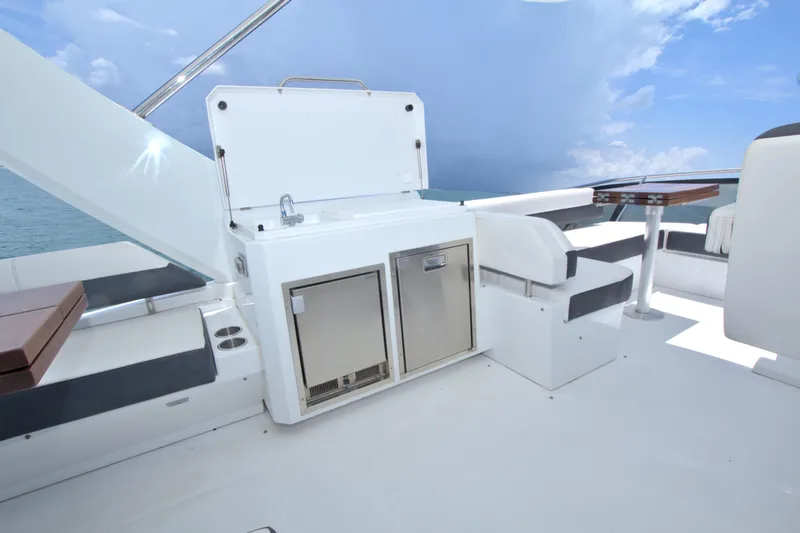 Slide: The Image of Luxurious 2018 Cruisers Yachts 54 Fly deck with seating and kitchenette under a clear sky. - 12