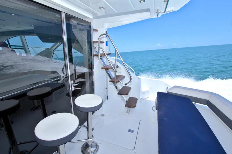 Slide: The Image of Luxurious 2018 Cruisers Yachts 54 Fly with ocean view, sleek seating, and elegant staircase. - 19