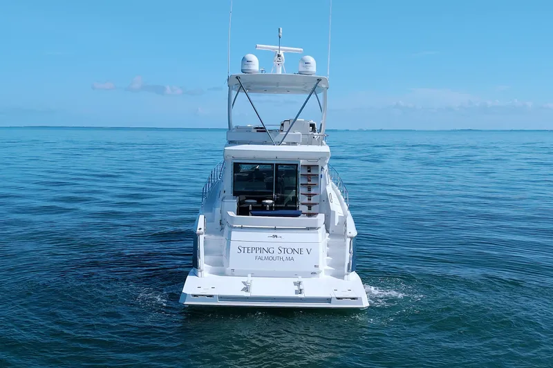 Slide: The Image of 2018 Cruisers Yachts 54 Fly on open water, rear view, clear blue sky. - 2