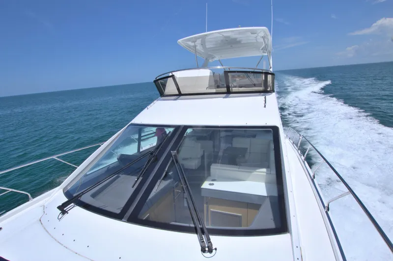 Slide: The Image of 2018 Cruisers Yachts 54 Fly cruising on open water under clear blue skies. - 27