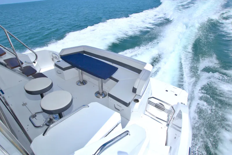 Slide: The Image of 2018 Cruisers Yachts 54 Fly cruising on open water, featuring sleek seating area. - 29