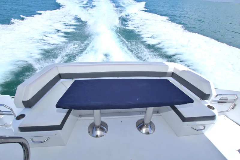 Slide: The Image of 2018 Cruisers Yachts 54 Fly deck with seating and table, cruising on open water. - 30