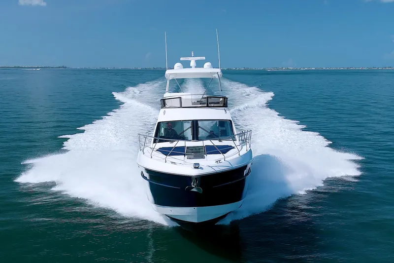 Slide: The Image of 2018 Cruisers Yachts 54 Fly cruising on open water, creating a dynamic wake. - 7