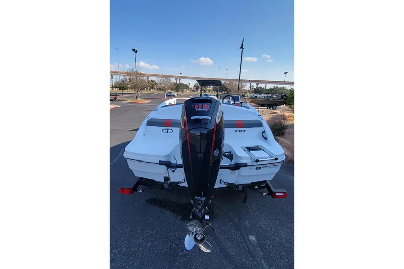 Slide: The Image of 2025 Tahoe T18 boat with outboard motor in a parking lot. - 2