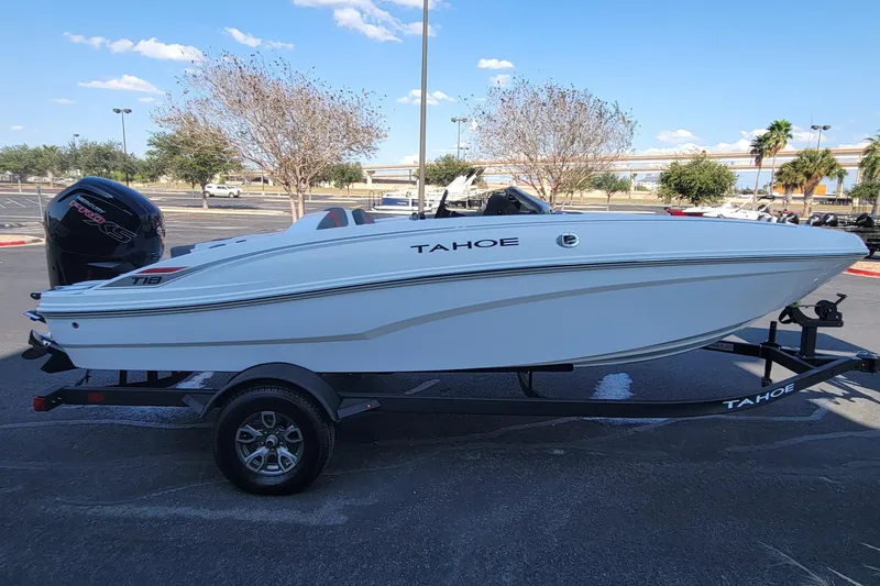 Slide: The Image of 2025 Tahoe T18 boat on trailer in parking lot under clear sky. - 1