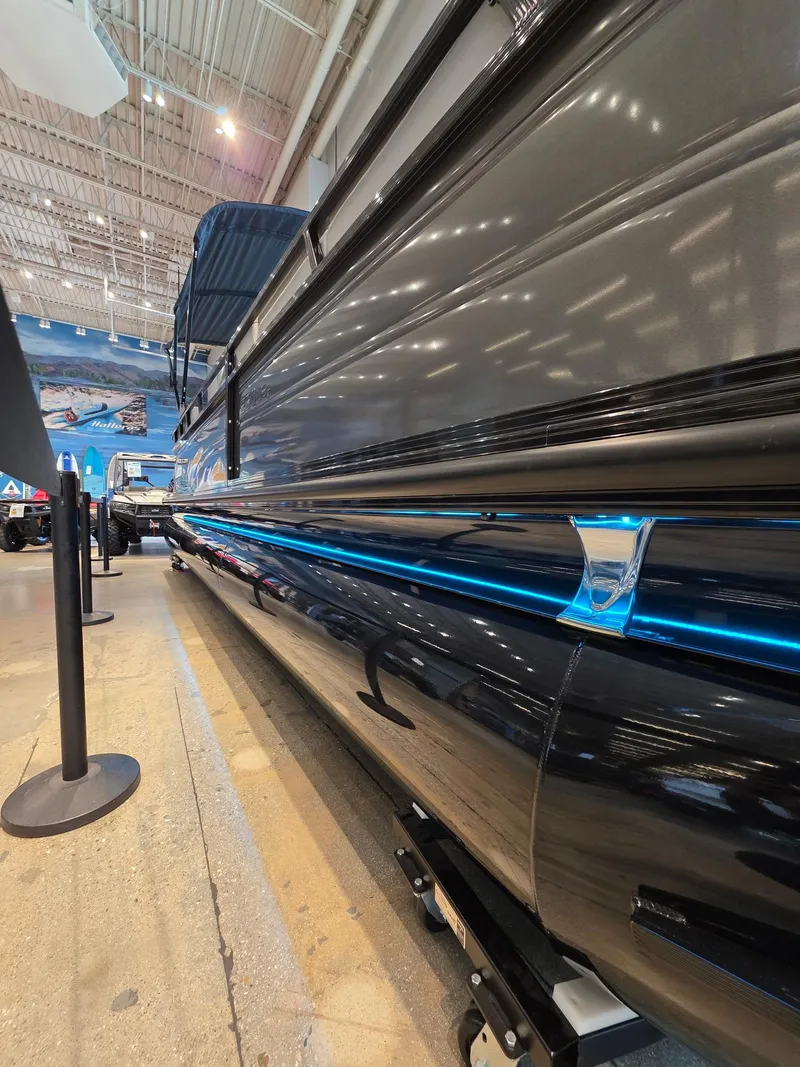 Slide: The Image of 2025 Regency 250 LE3 pontoon boat displayed indoors, showcasing sleek design and modern features. - 5