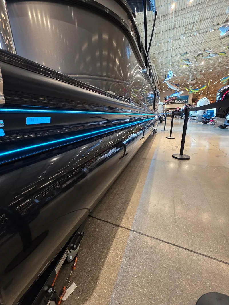 Slide: The Image of 2025 Regency 250 LE3 pontoon boat with sleek design and blue LED lighting. - 6