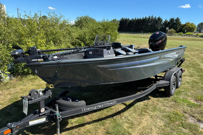 Slide: The Image of 2025 Ranger VS1882SC Reata boat on trailer, parked on grass under clear blue sky. - 1