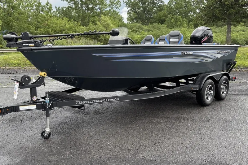 Slide: The Image of 2025 Ranger VS1882SC Reata boat on trailer, parked outdoors with lush greenery background. - 1