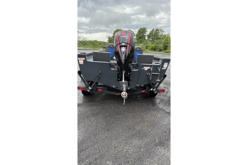 Slide: The Image of 2025 Ranger VS1882SC Reata boat rear view on wet pavement, cloudy sky background. - 4