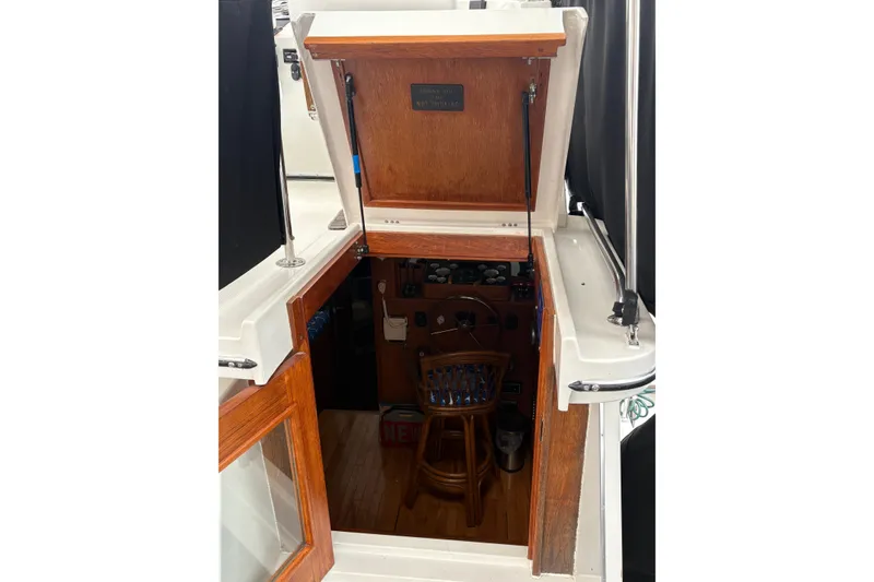 Slide: The Image of 1988 Cooper Prowler boat with gray cover, docked alongside another vessel. - 23