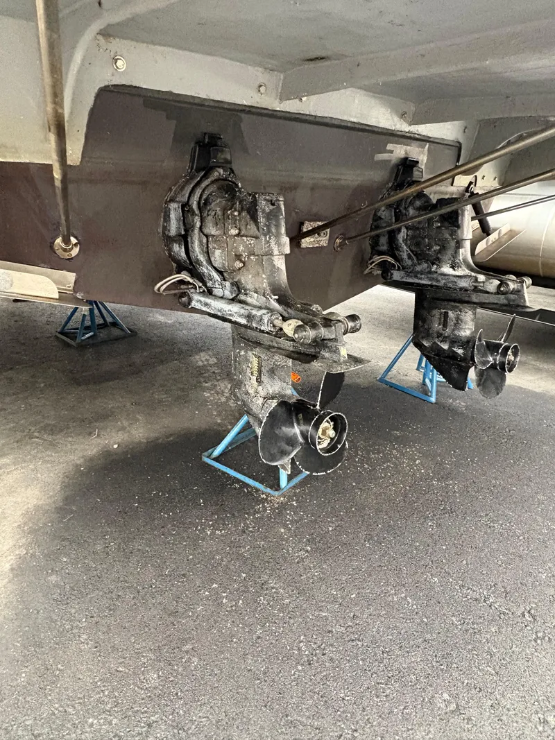 Slide: The Image of 1988 Cooper Prowler boat outdrives on stands, displayed in a maintenance area. - 3