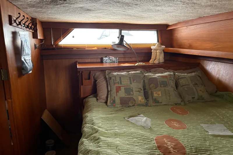 Slide: The Image of Cozy cabin bedroom in 1988 Cooper Prowler boat with wooden interior and decorative pillows. - 39
