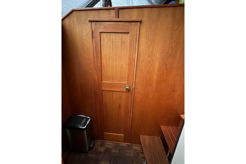 Slide: The Image of Wooden interior door in 1988 Cooper Prowler boat, with adjacent trash can and steps. - 61