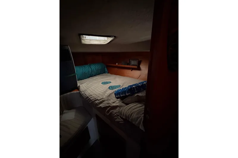 Slide: The Image of Cozy cabin interior of a 1988 Cooper Prowler boat with a skylight and bedding. - 67