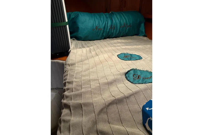 Slide: The Image of Cozy interior of a 1988 Cooper Prowler with embroidered bedding and teal accents. - 71