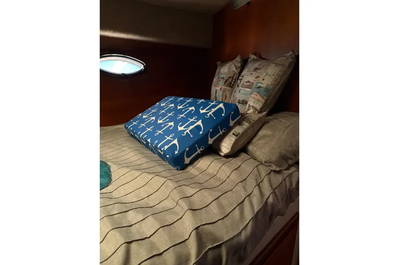 Slide: The Image of Cozy cabin bed in 1988 Cooper Prowler with nautical-themed pillows and striped bedding. - 72