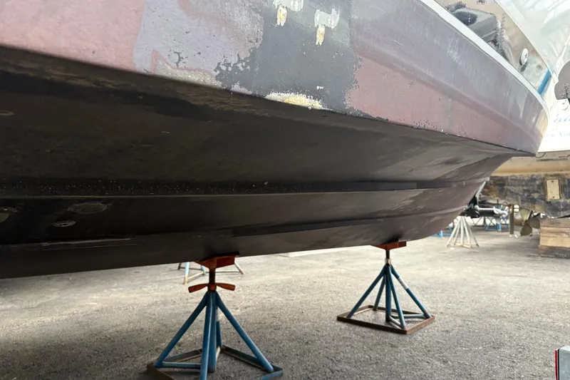 Slide: The Image of 1988 Cooper Prowler boat hull on stands, showing wear and maintenance needs. - 78