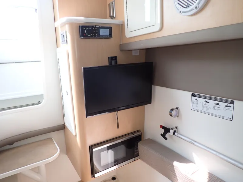 Slide: The Image of 2022 World Cat 325 DC interior with TV, microwave, and seating area. - 23