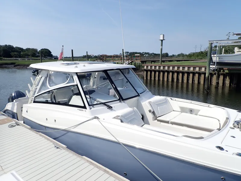 Slide: The Image of 2022 World Cat 325 DC boat docked by a serene waterfront. - 3