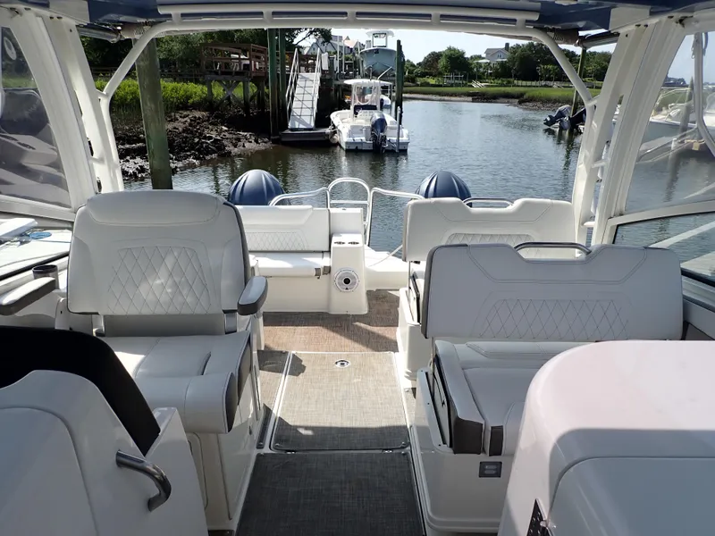 Slide: The Image of Interior view of 2022 World Cat 325 DC boat, featuring luxurious seating and scenic waterway. - 6