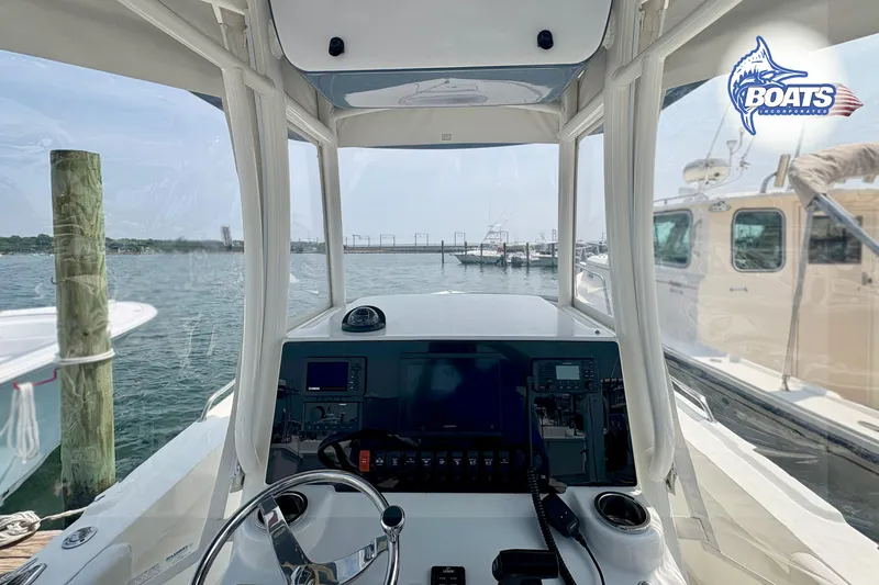 Slide: The Image of Parker 2300 Center Console 2021 boat interior with navigation equipment, docked at marina. - 8