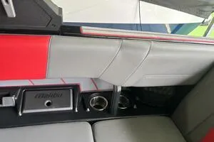 Slide: The Image of 2022 Malibu Wakesetter 23 LSV interior with red and gray upholstery, cup holders. - 13