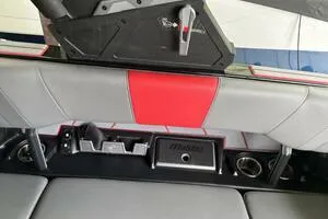 Slide: The Image of 2022 Malibu Wakesetter 23 LSV interior with gray and red seating, cup holders, and storage. - 16