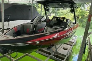 Slide: The Image of 2022 Malibu Wakesetter 23 LSV boat in dock, sleek design, red and black exterior. - 4