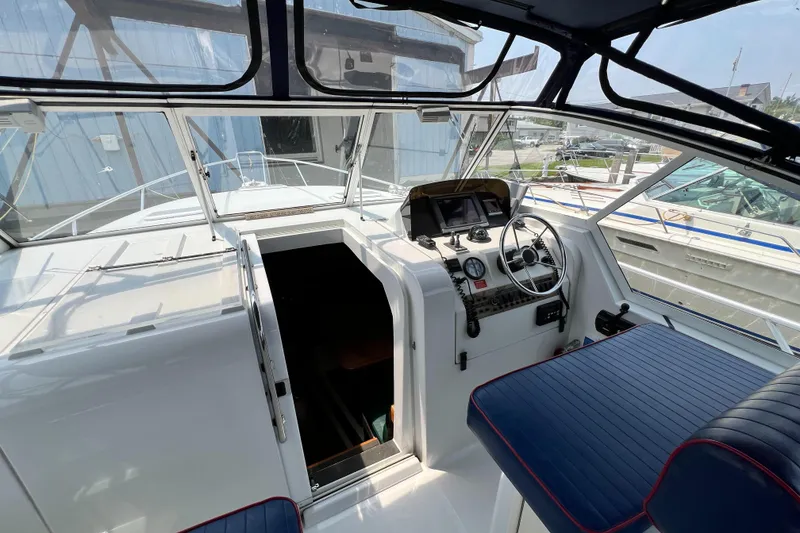 Slide: The Image of 2001 Mainship 34 PILOT boat cockpit with steering wheel, gauges, and blue seating. - 15