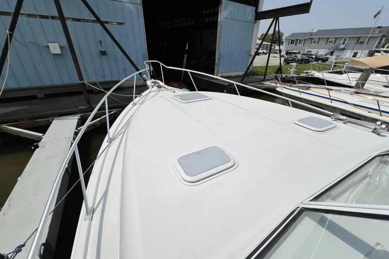 Slide: The Image of 2001 Mainship 34 PILOT boat docked near a blue boathouse. - 19