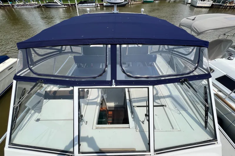 Slide: The Image of 2001 Mainship 34 PILOT boat with blue canopy docked at marina. - 20