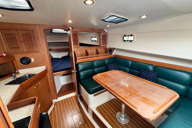 Slide: The Image of Interior of 2001 Mainship 34 PILOT boat with wood finishes and green seating. - 24