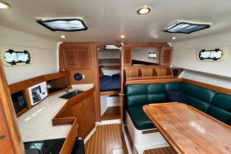 Slide: The Image of Interior of 2001 Mainship 34 PILOT yacht with kitchen, seating, and wood finishes. - 25