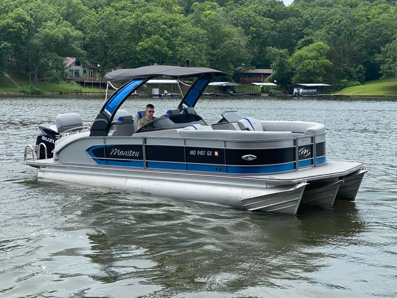 Slide: The Image of 2022 Manitou 25 LX SRW SHP pontoon boat on a scenic lake. - 10