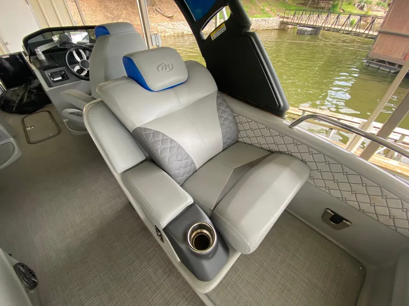 Slide: The Image of 2022 Manitou 25 LX SRW SHP boat interior with luxurious seating and cup holder. - 19