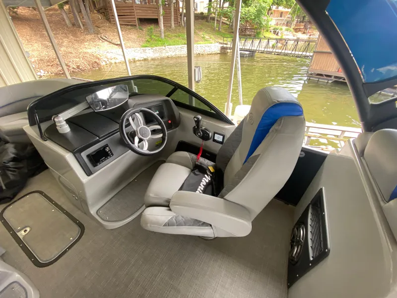 Slide: The Image of 2022 Manitou 25 LX SRW SHP boat interior with steering wheel and captain's seat. - 22