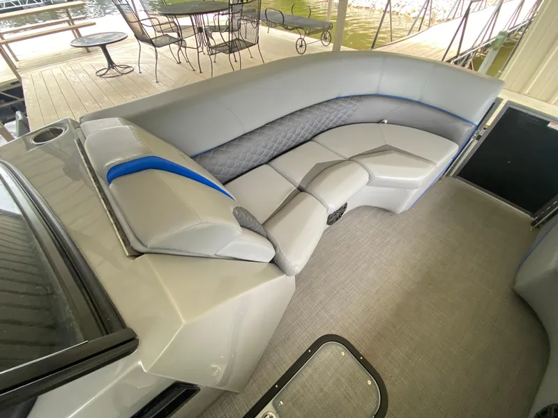 Slide: The Image of 2022 Manitou 25 LX SRW SHP boat interior with gray seating and blue accents. - 25