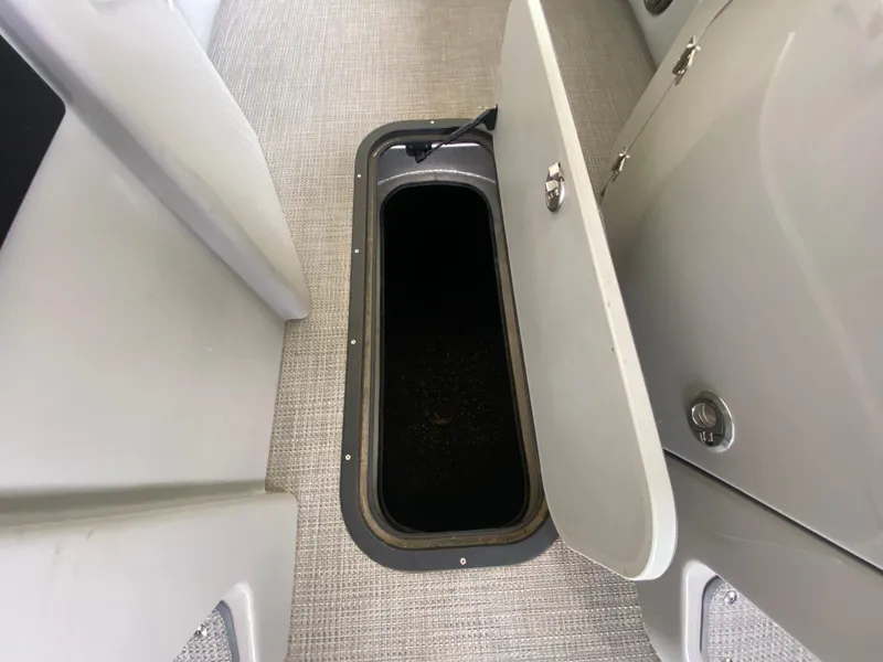 Slide: The Image of Open storage compartment on 2022 Manitou 25 LX SRW SHP boat interior. - 27