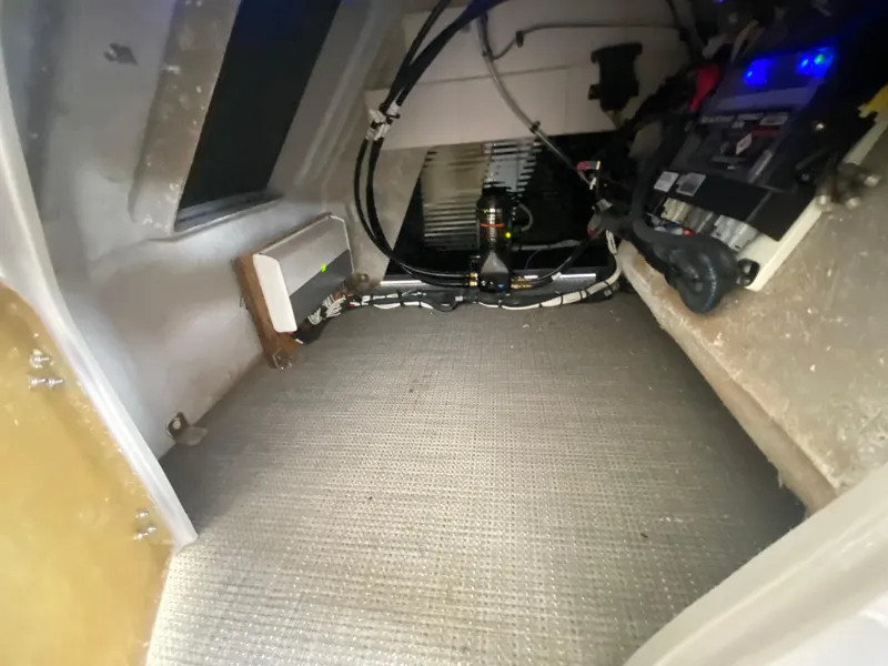 Slide: The Image of Interior view of 2022 Manitou 25 LX SRW SHP boat's storage compartment with wiring and equipment. - 28