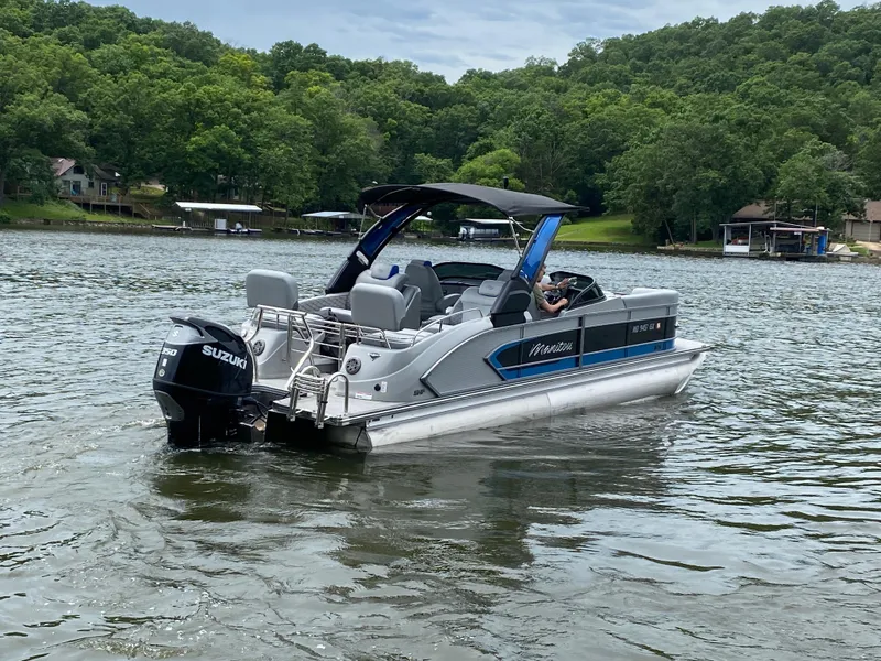 Slide: The Image of 2022 Manitou 25 LX SRW SHP pontoon boat on a scenic lake. - 7