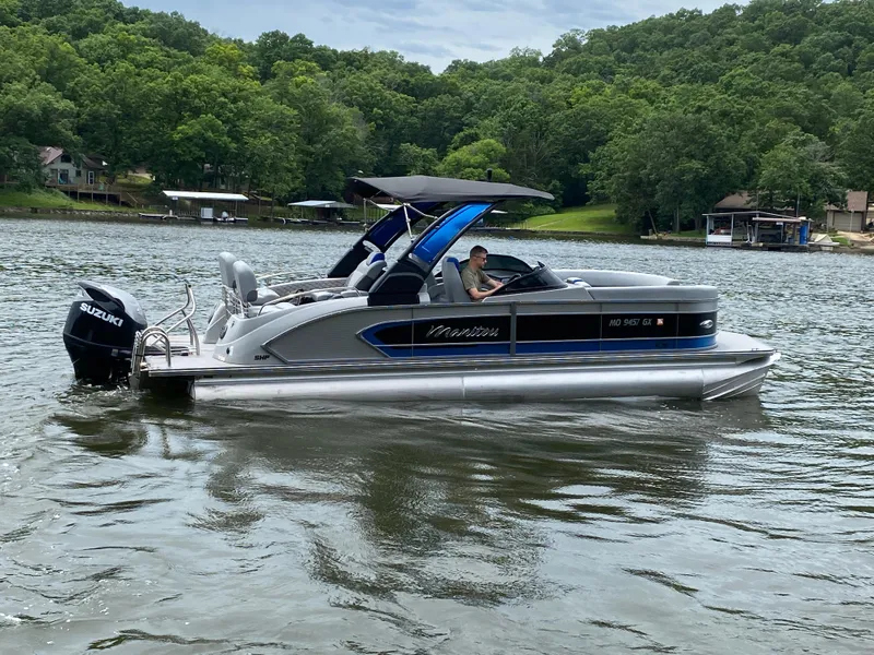 Slide: The Image of 2022 Manitou 25 LX SRW SHP pontoon boat on a scenic lake. - 8