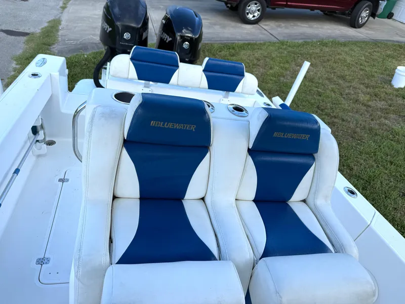 Slide: The Image of 2015 Bluewater 2550 boat with blue and white seating, dual Mercury engines. - 13