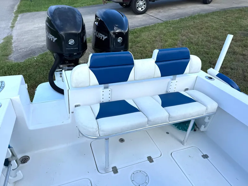Slide: The Image of 2015 Bluewater 2550 boat with dual Mercury engines and blue-white seating. - 14