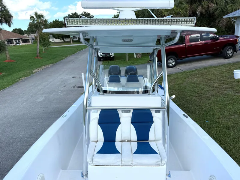 Slide: The Image of 2015 Bluewater 2550 boat with blue and white seating, parked near a red truck. - 15
