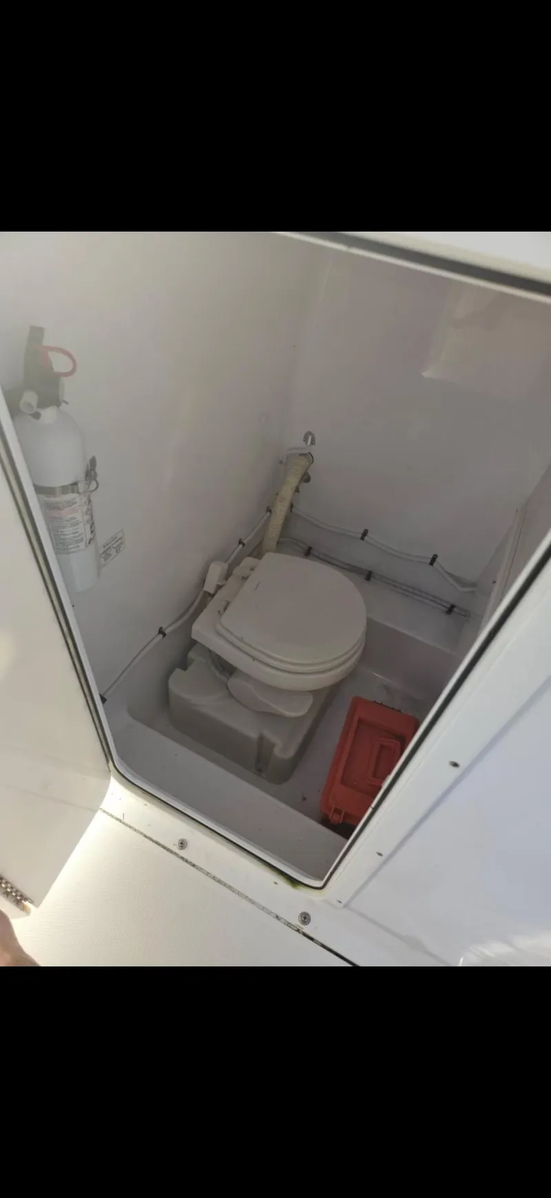 Slide: The Image of 2015 Bluewater 2550 boat interior with toilet and fire extinguisher. - 16
